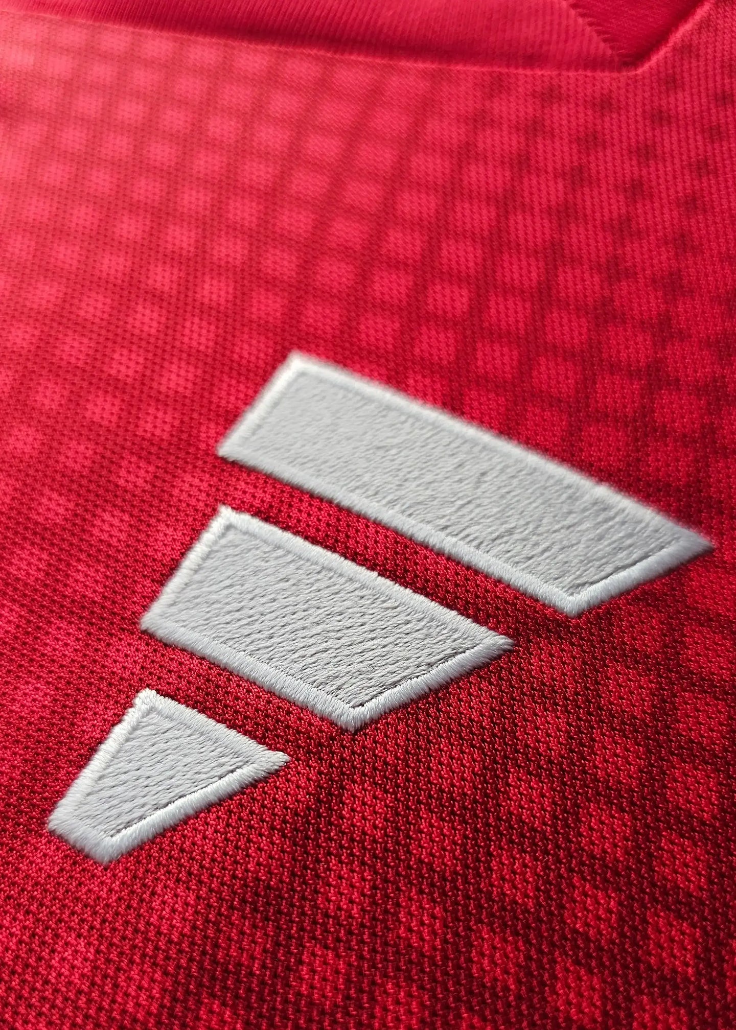 Close-up of the white adidas logo on the red fabric of Wout Weghorst's Ajax signed jersey.
