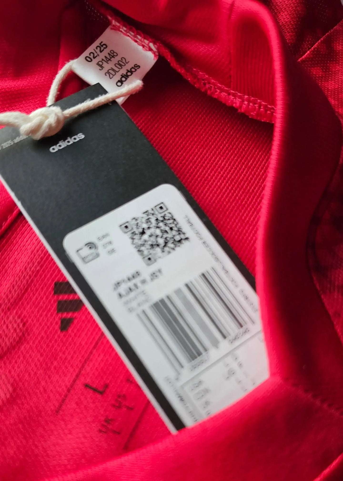 Red adidas tag with code 021/25, style JP1449, size L on Wout Weghorst Ajax jersey.