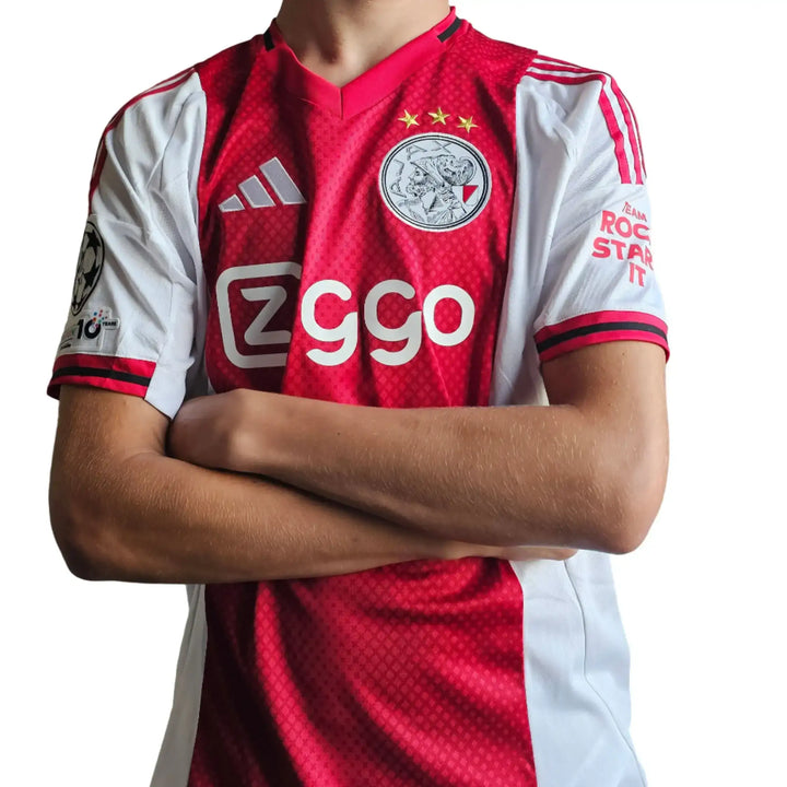 Red and white Ajax football shirt featuring ziggo logo, three stars, and adidas branding.
