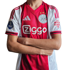 Ajax home shirt with red and white colors, features two stars, Ziggo sponsor, and VRIENDEN LOTERIJ logo.