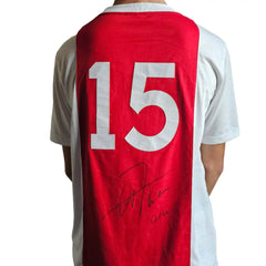 A red and white Ajax football shirt featuring No. 15 and the signature of Arie Haan.
