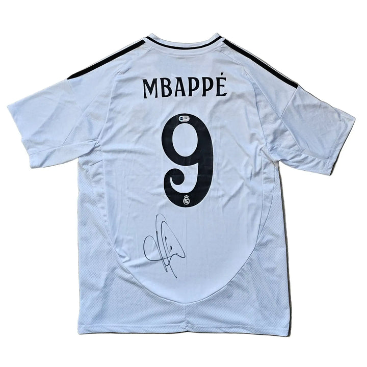 Back view showing signature and No. 9 of Kylian Mbappé on Real Madrid football shirt.