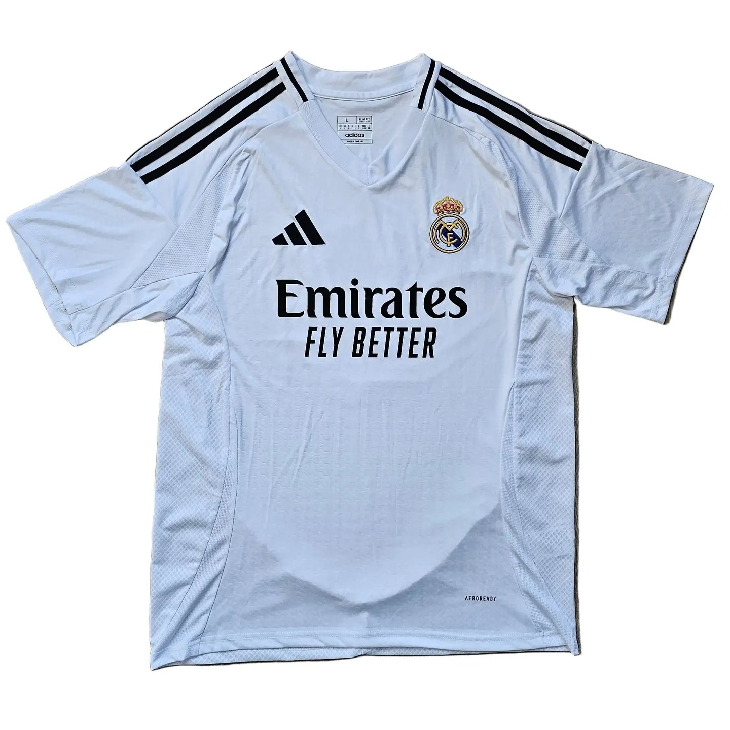 White Real Madrid football shirt with black adidas stripes and 'Emirates FLY BETTER' sponsor text.