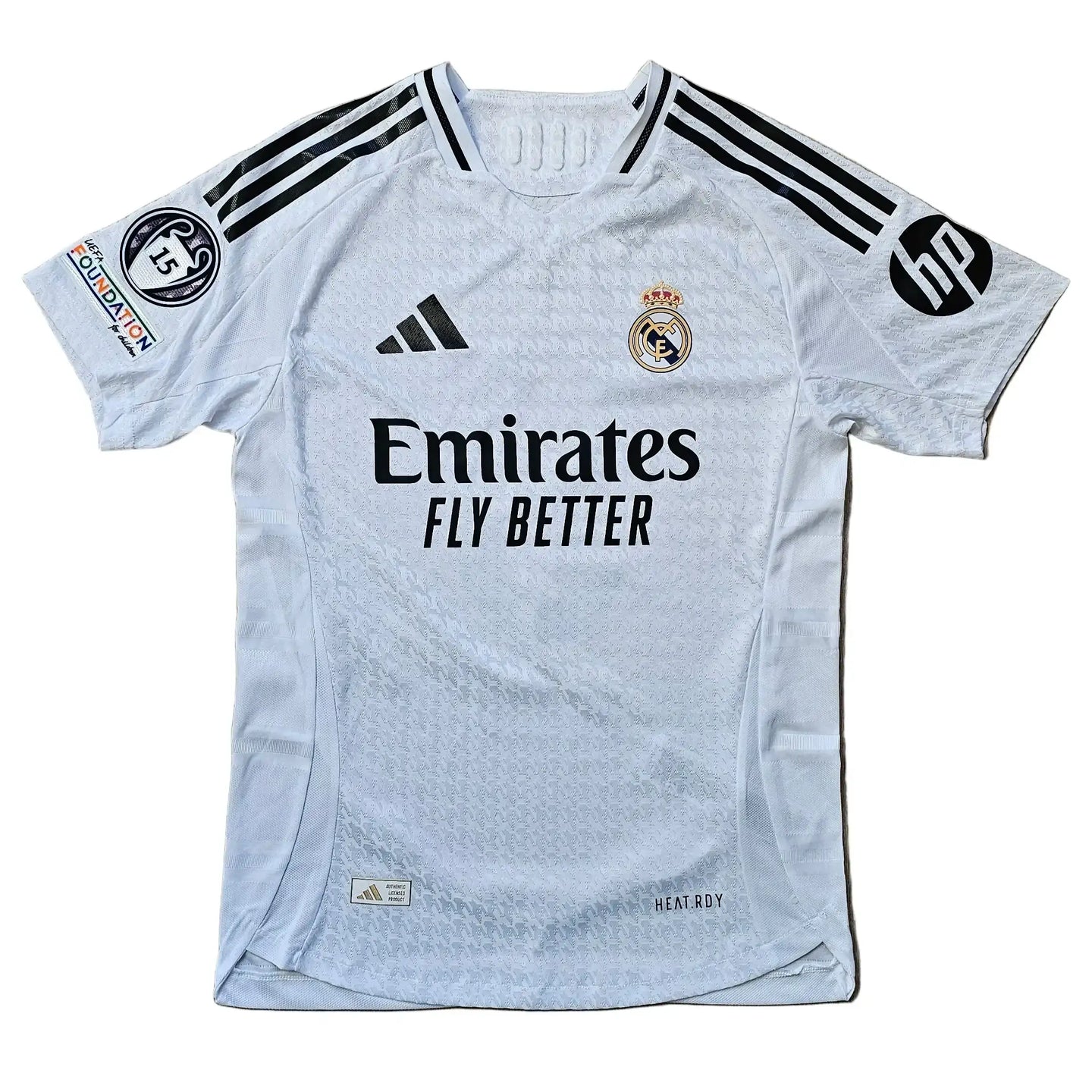 White Real Madrid shirt featuring crest, adidas logo, and Emirates Fly Better sponsor.