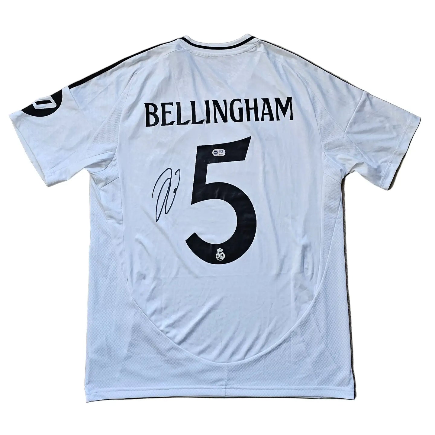 White Real Madrid shirt featuring Bellingham's name and No. 5, with a visible signature.
