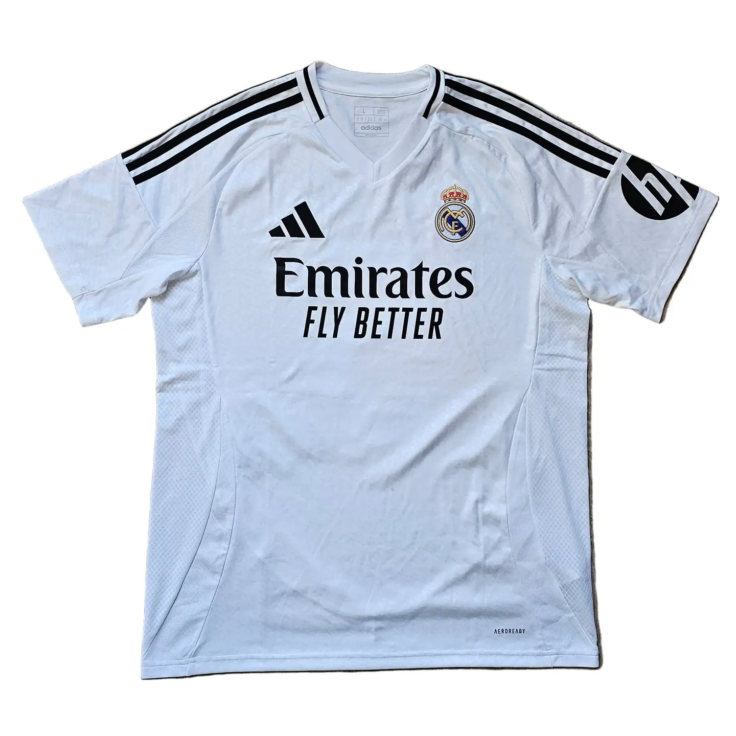 White Real Madrid football shirt with black adidas stripes and Emirates Fly Better logo.