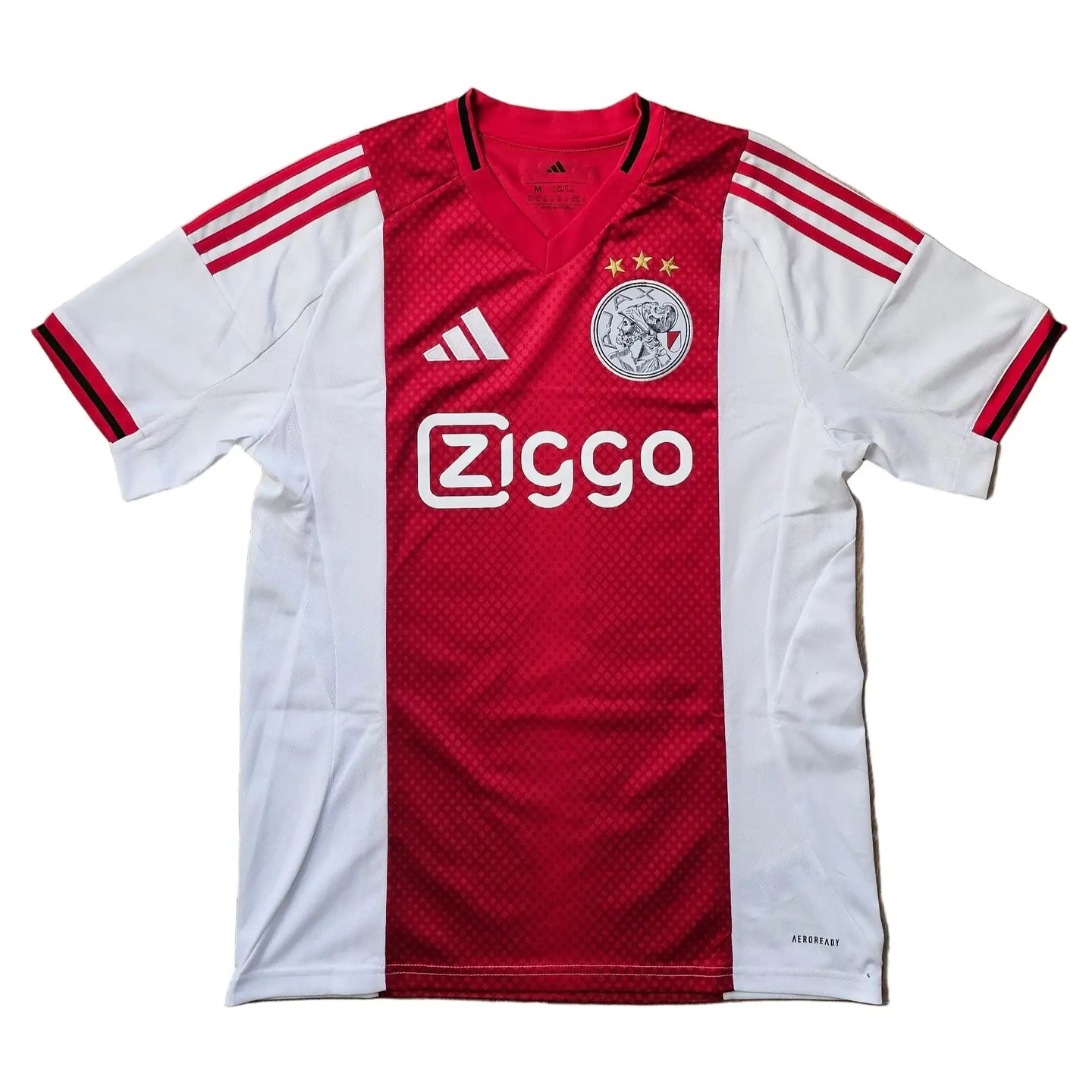 Red and white Ajax football shirt with Ziggo sponsor, three stars, and adidas logo details.