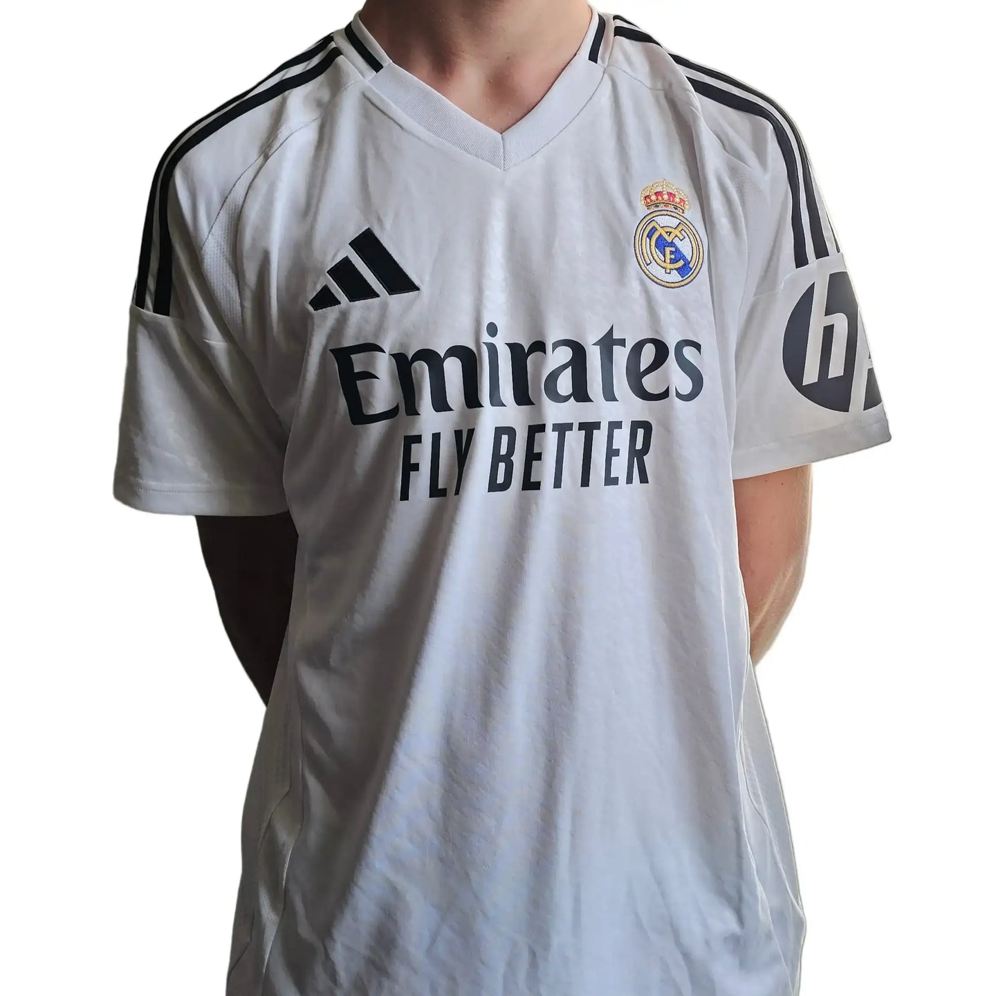 White Real Madrid shirt featuring 'Emirates Fly Better' sponsor, adidas logo, and club crest.