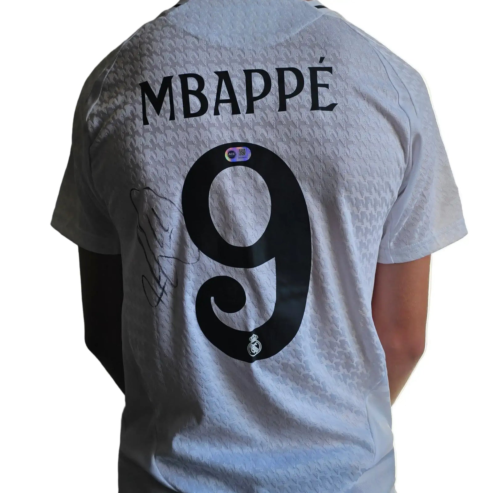 White signed football shirt featuring MBAPPÉ and No. 9 with Real Madrid crest.