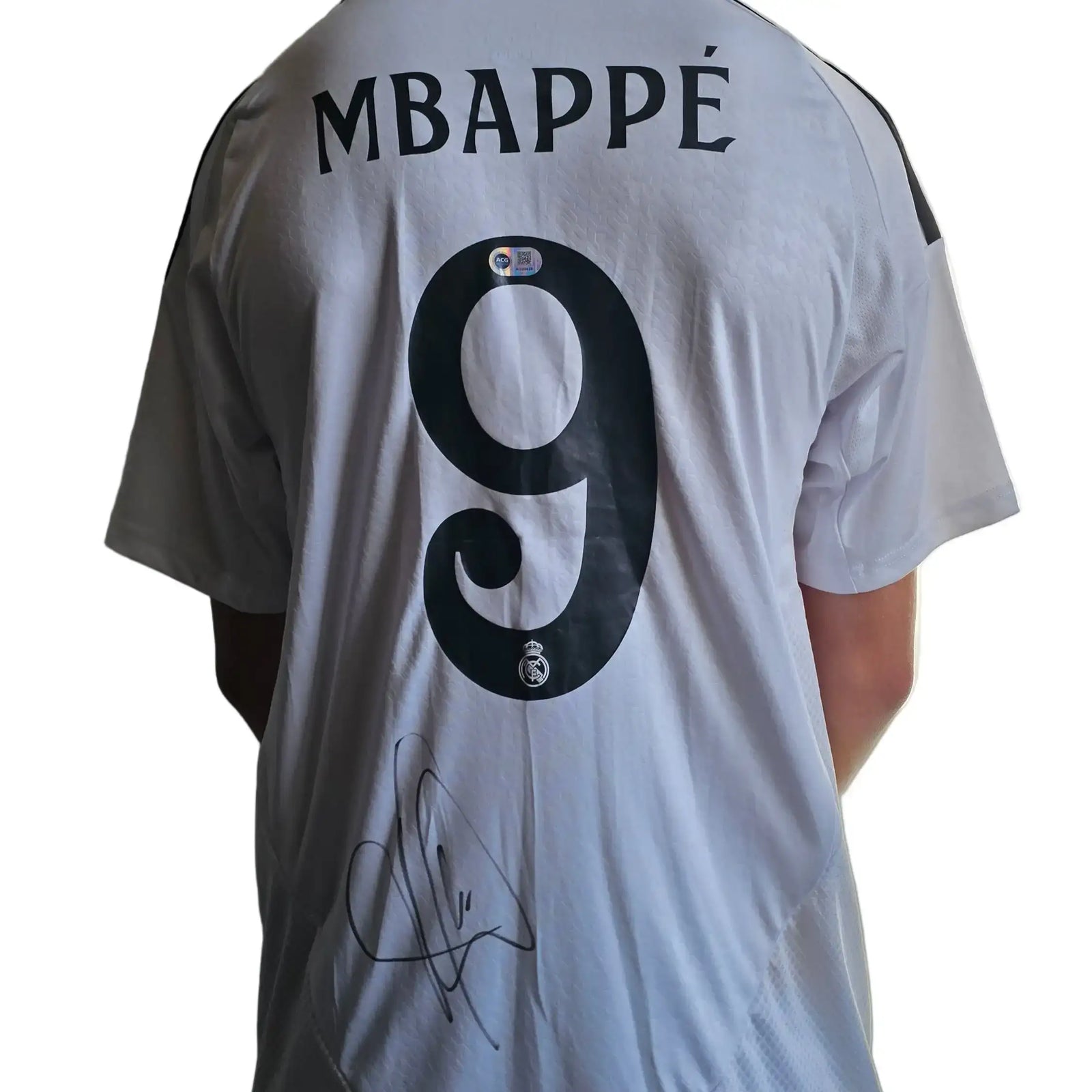 White football shirt featuring the name MBAPPÉ, No. 9, and a visible signature.