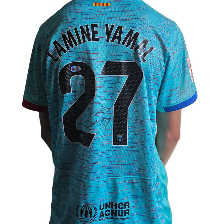 Lamine Yamal No. 27 Barcelona away shirt featuring a visible signature and UNHCR logo.