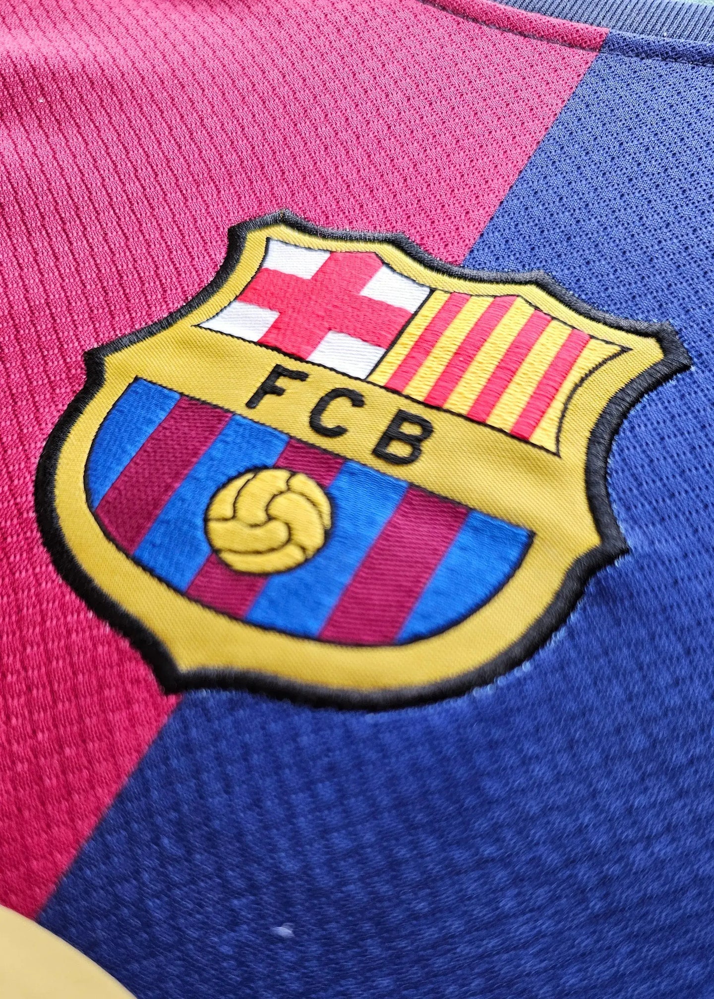 FC Barcelona crest with four stripes and ball emblem, displayed in blue and red colors.
