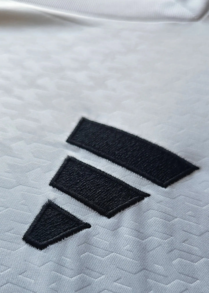 Close-up of the black adidas logo featuring three stripes on white fabric.