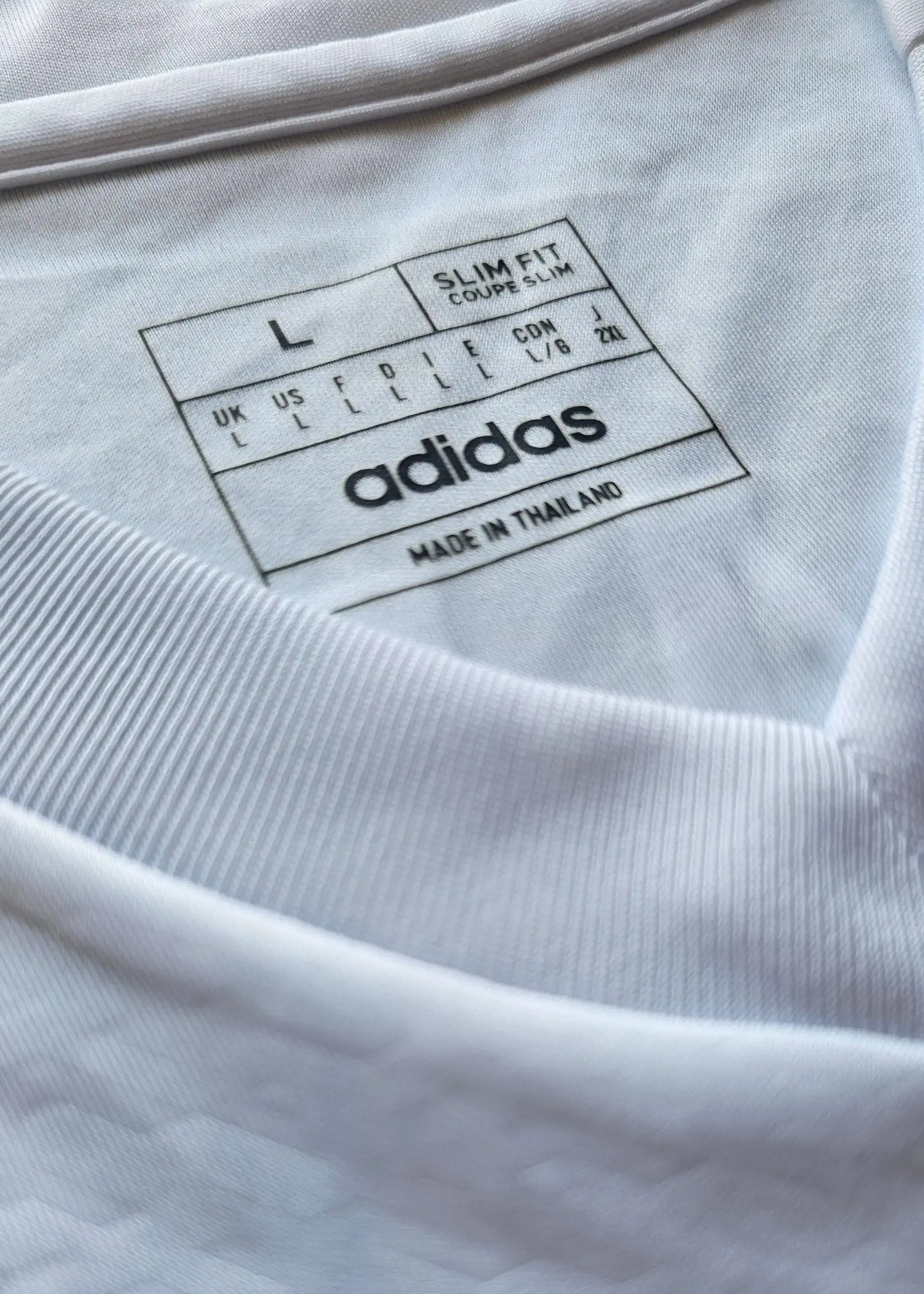 Size L label with slim fit details, adidas branding, and made in Thailand text.