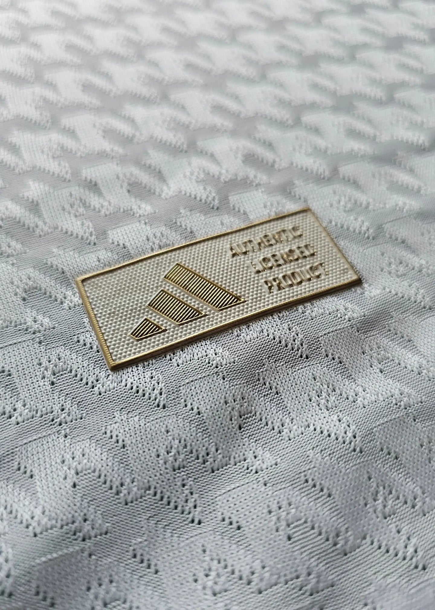 Detail of the adidas Authentic Liverpool Product tag on a white football shirt.