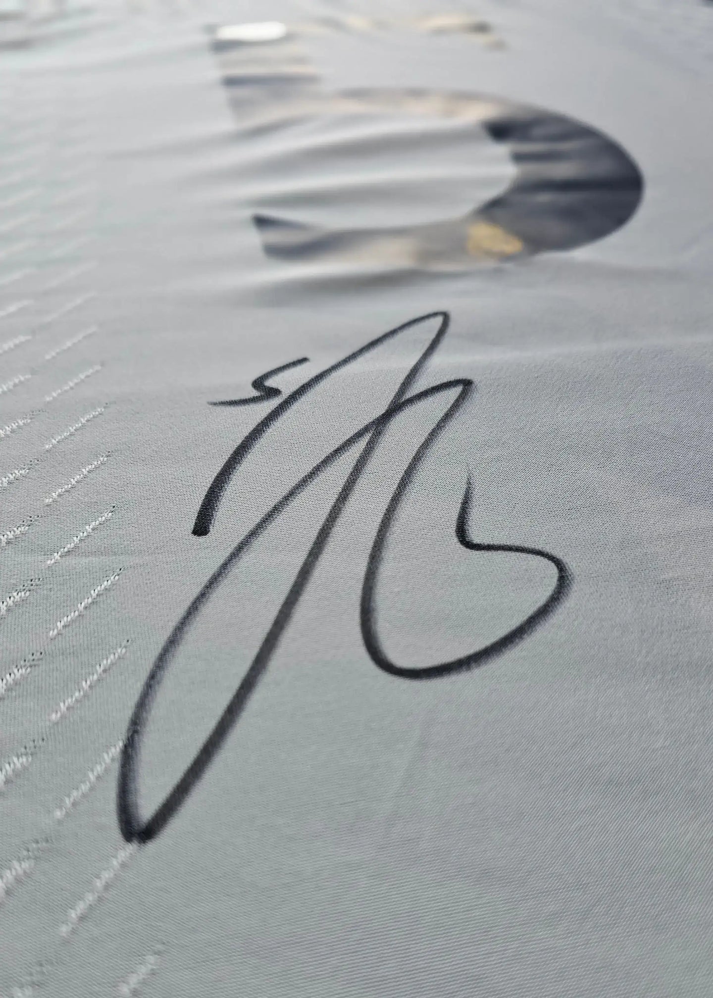 Signature of Jude Bellingham on a Real Madrid 2023-2024 football shirt fabric.