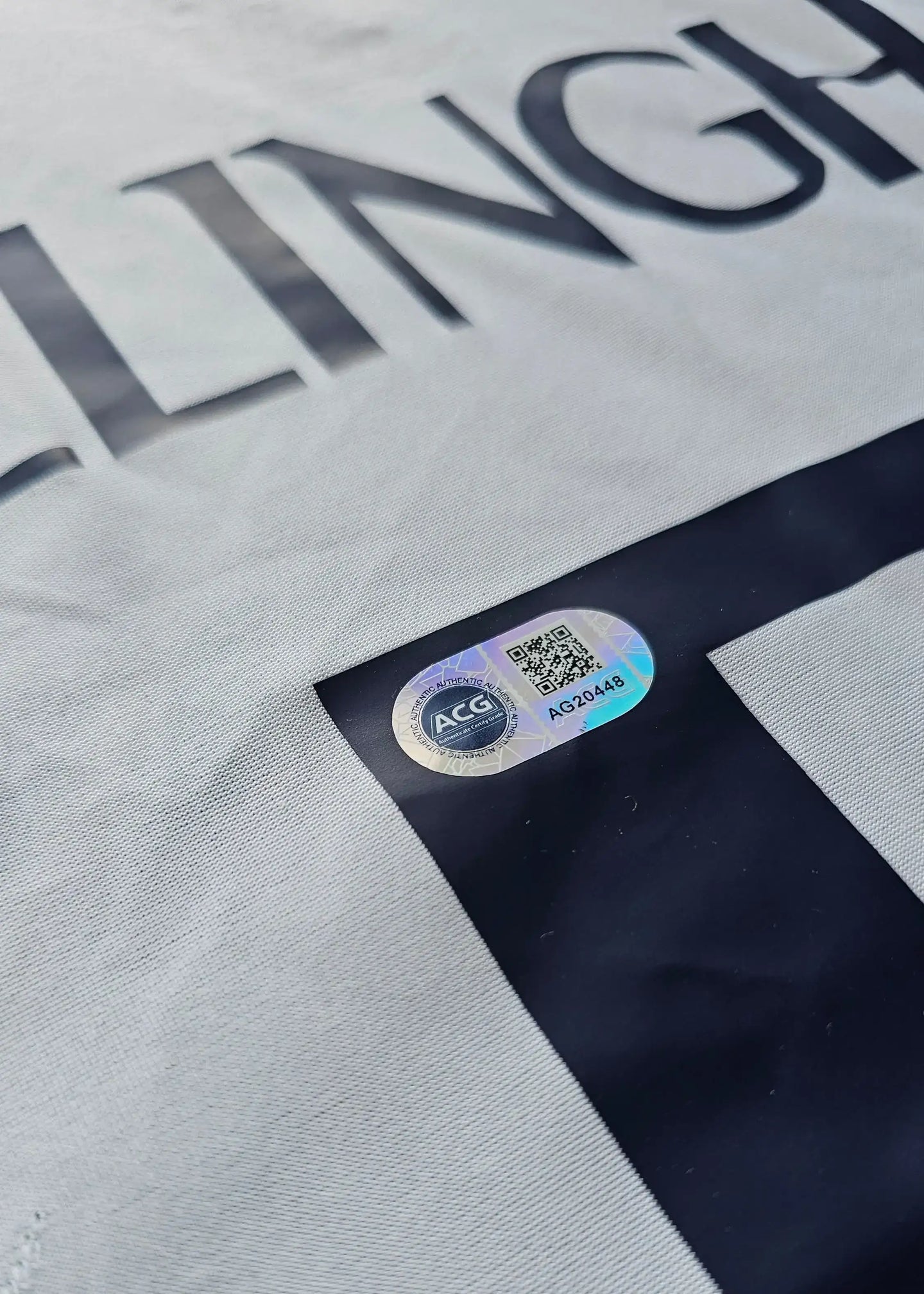 ACG certification sticker on Jude Bellingham signed Real Madrid shirt, featuring barcode AG20448.