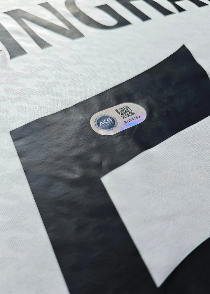 View of the signature detail and authenticity label on Jude Bellingham 5 Real Madrid shirt.