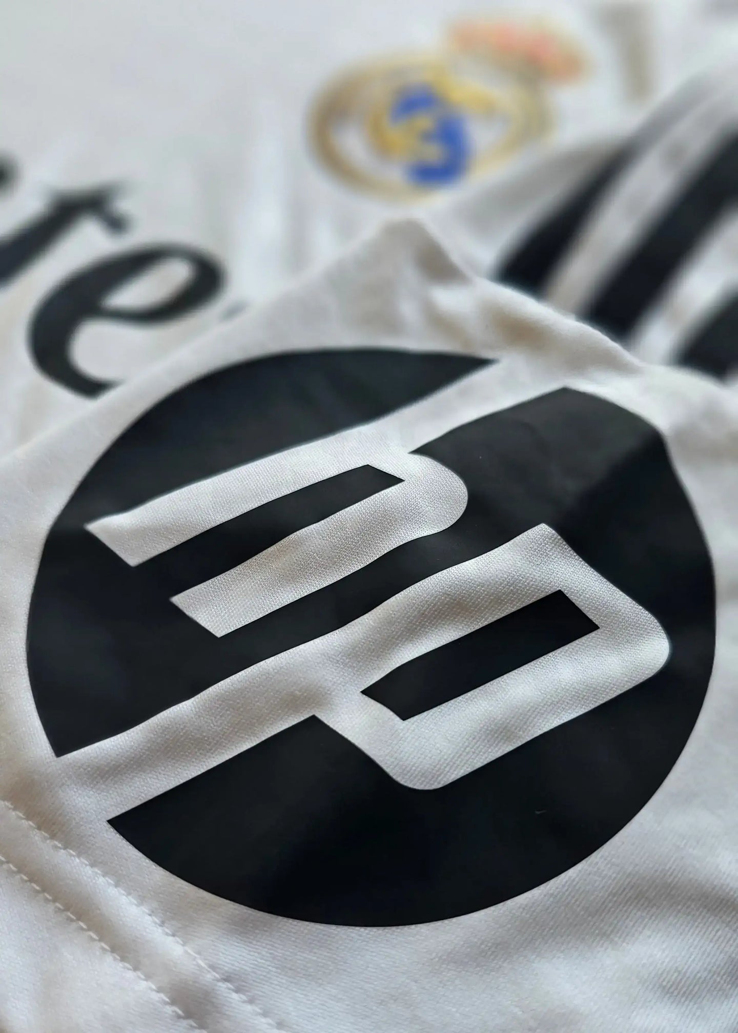 Close-up of the black No. 5 on a white Jude Bellingham signed Real Madrid shirt.
