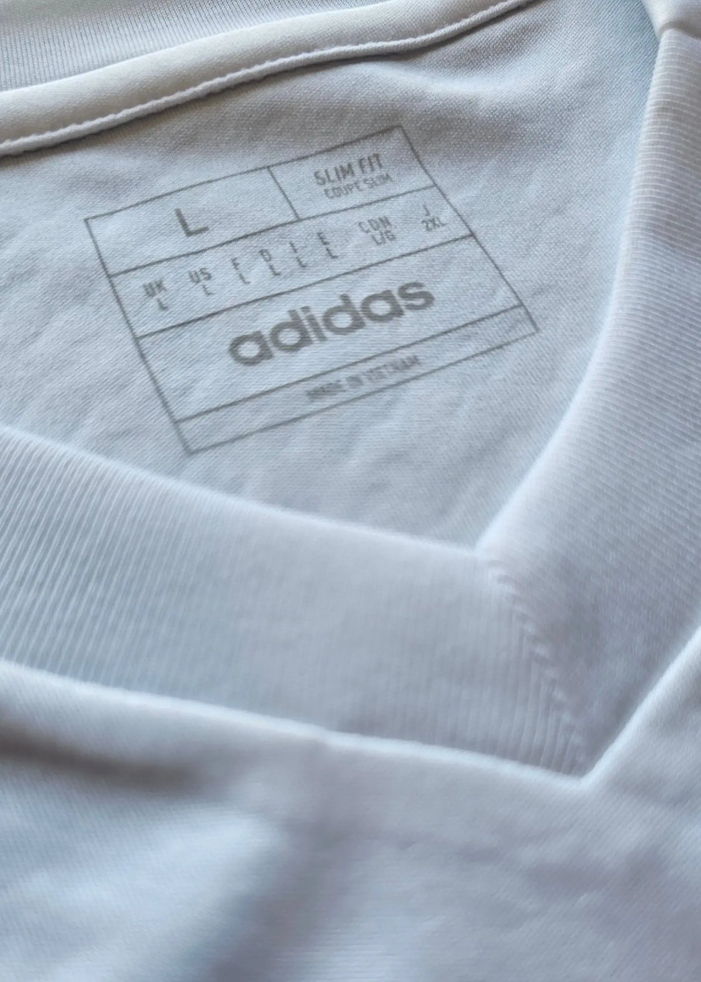 Label showing size L, slim fit, and adidas brand on the inner neck of the shirt.