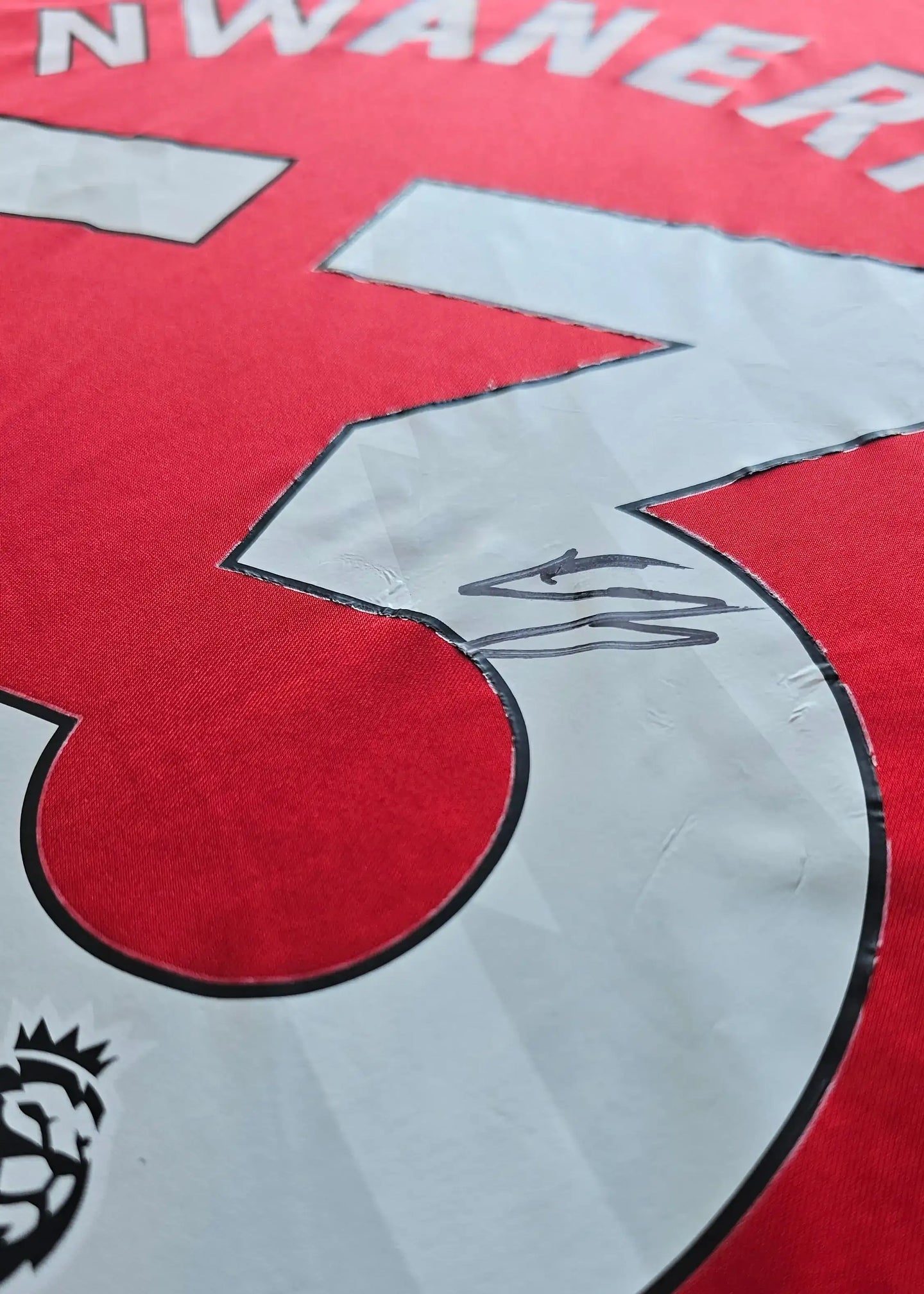 Close-up of No. 53 on the red Arsenal shirt, displaying the signature of Ethan Nwaneri.