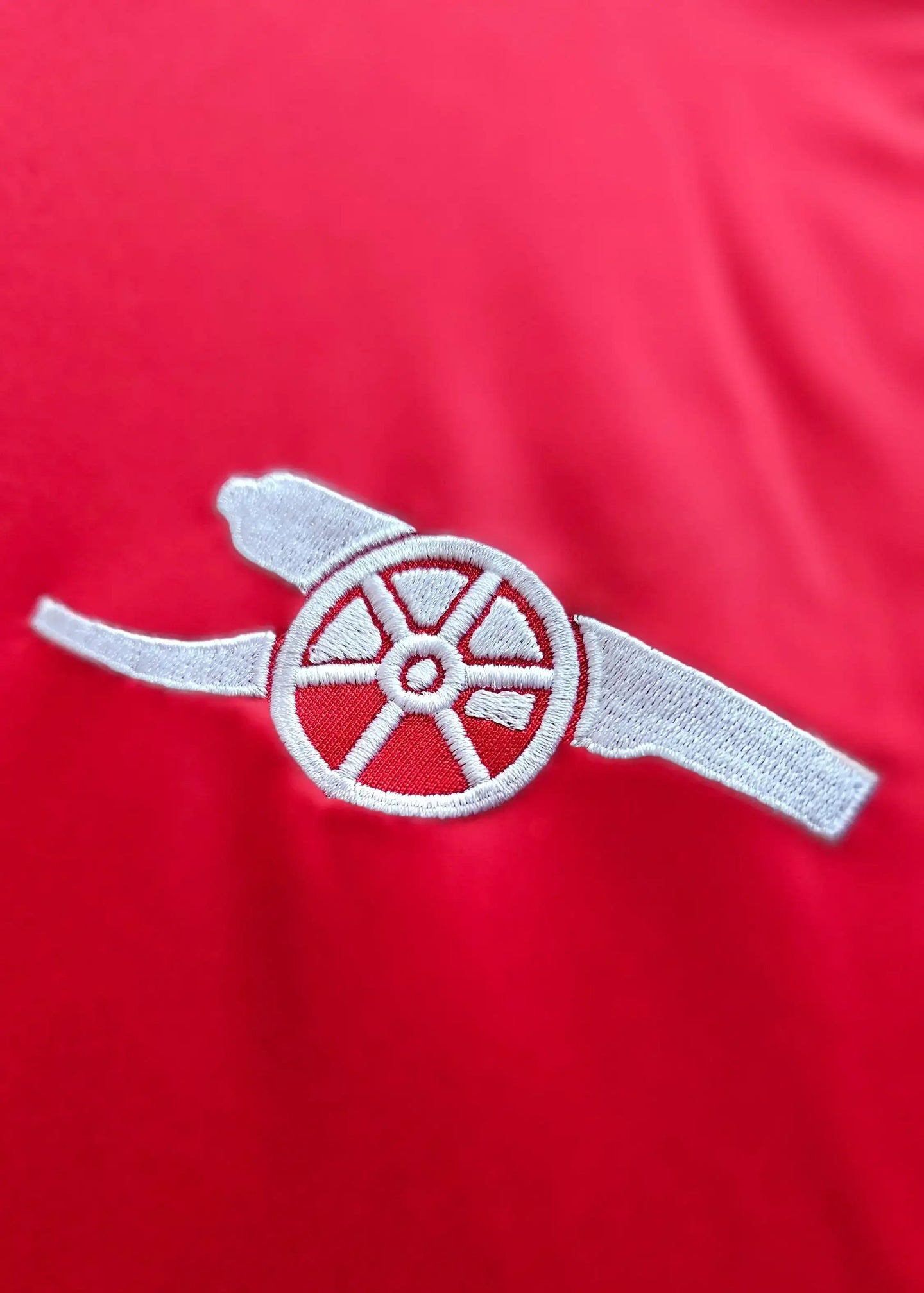 Arsenal crest embroidered in white on a vibrant red background.