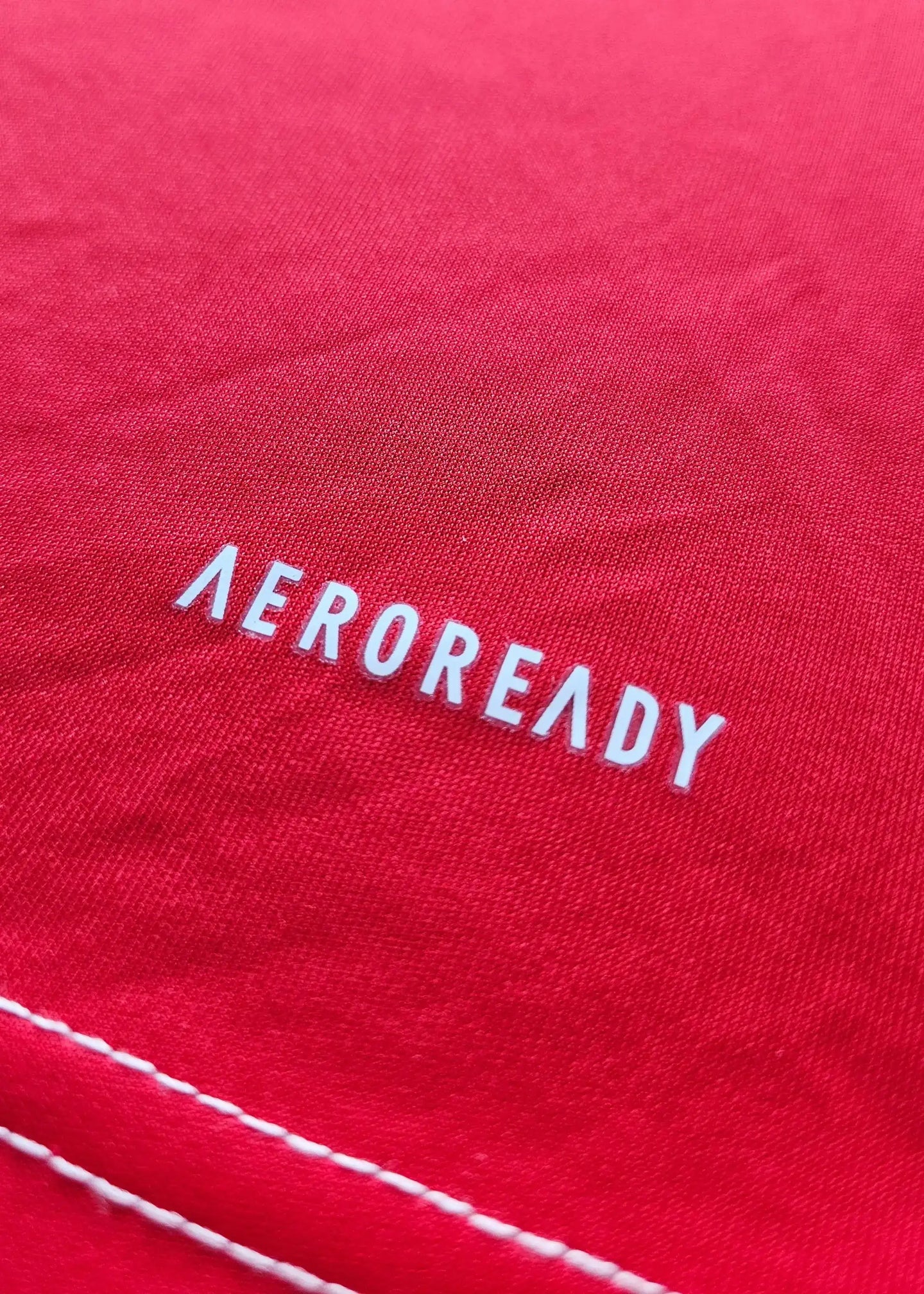Close-up of the AEROREADY branding on the red fabric of the Arsenal football shirt.