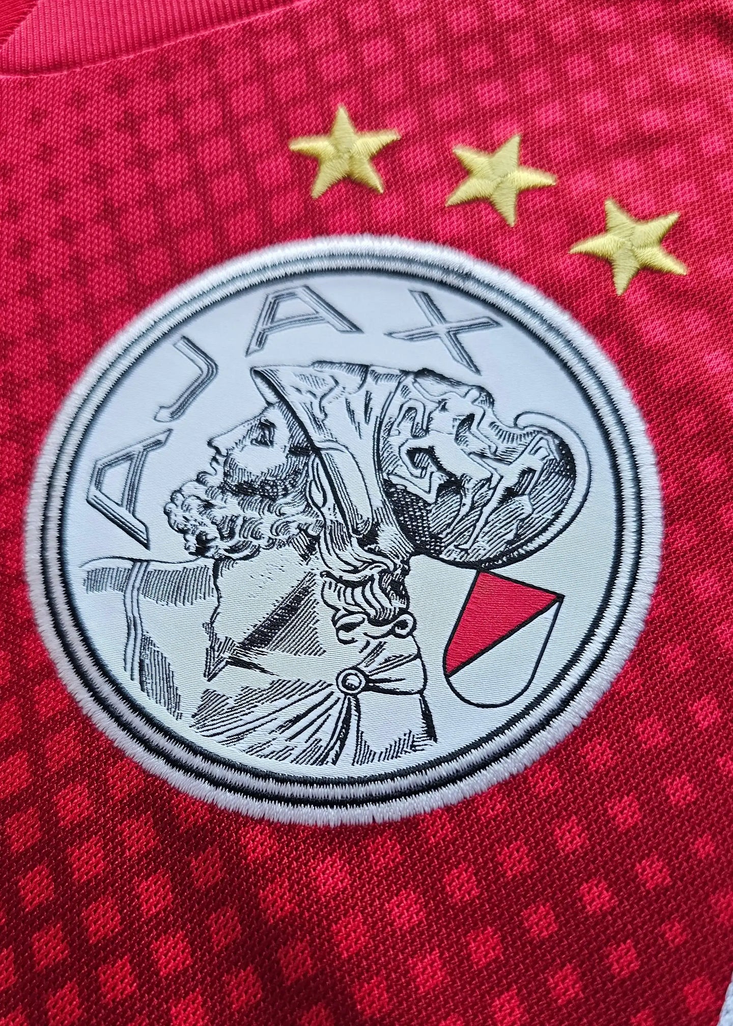 AFC Ajax crest in red and white with three gold stars above and detailed player profile.