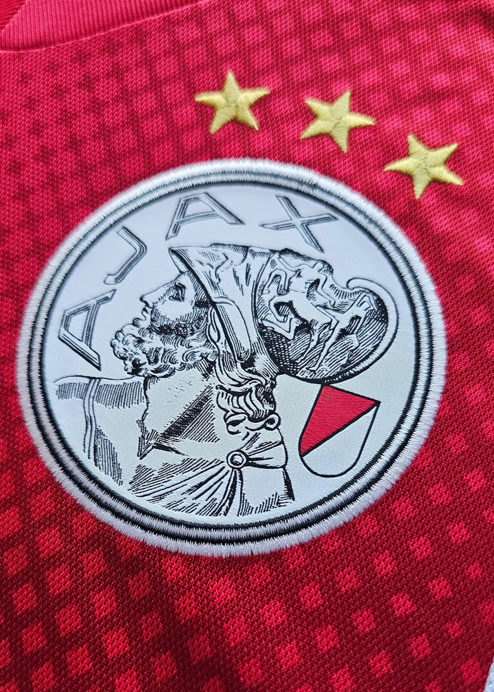 AFC Ajax crest in red and white with three gold stars above and detailed player profile.