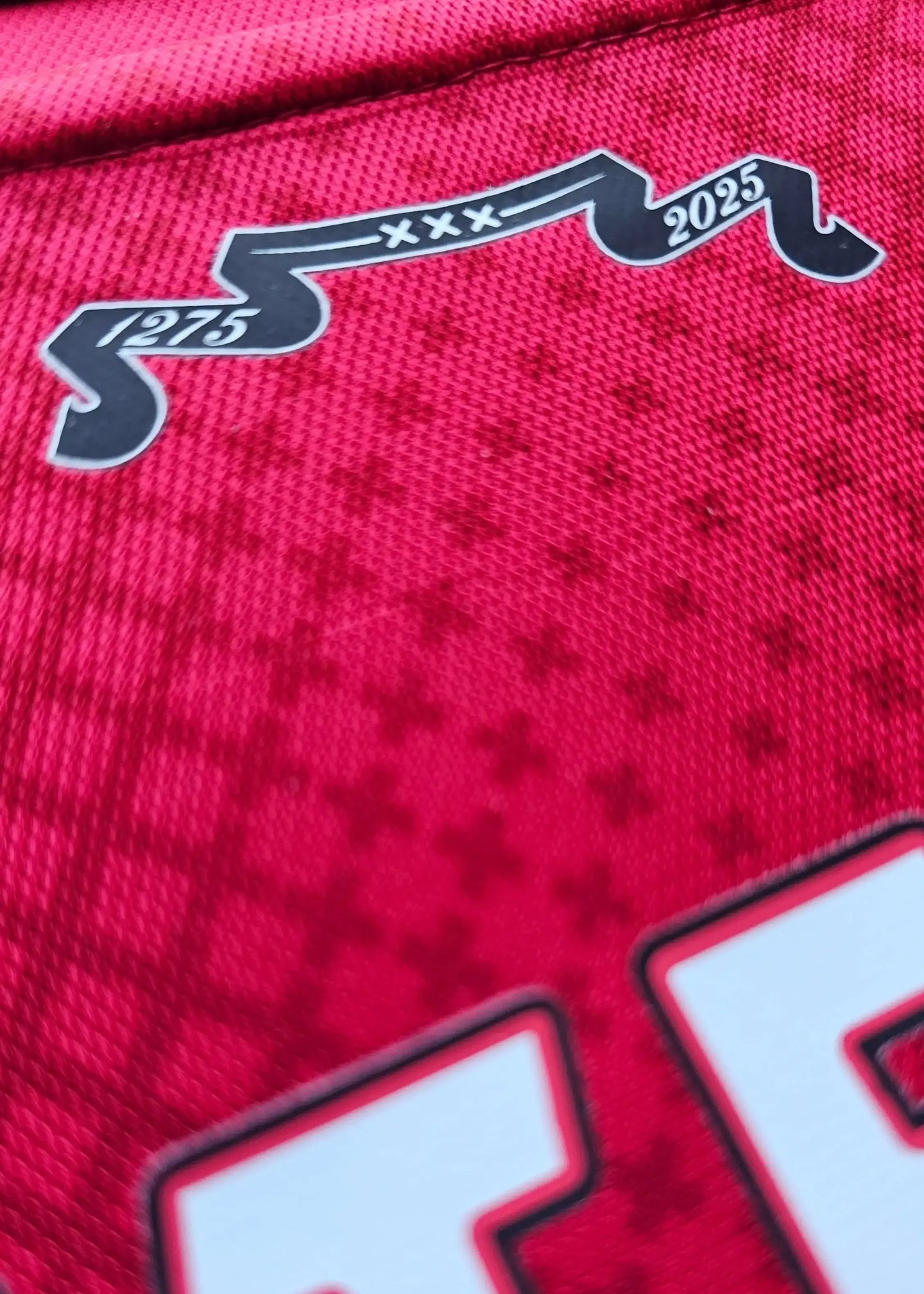 Detail view of a red Ajax shirt featuring No. 48 and 2025 in black detail.