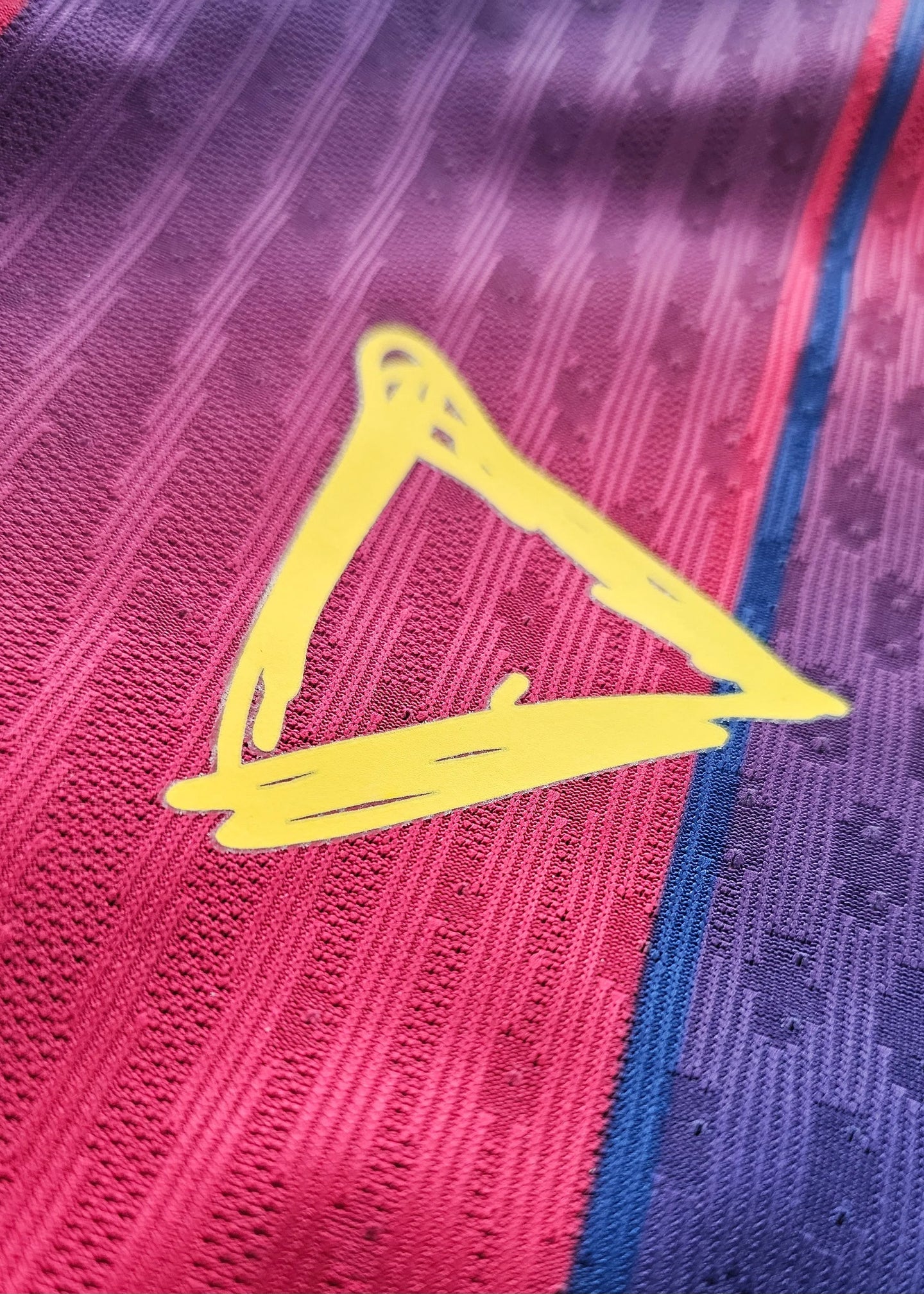 Close-up detail showing the signature in yellow on the FC Barcelona football shirt.