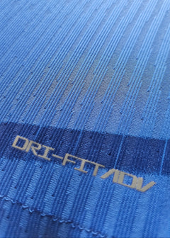 Close-up of the fabric texture with DRI-FIT ADV text on Chelsea blue shirt.