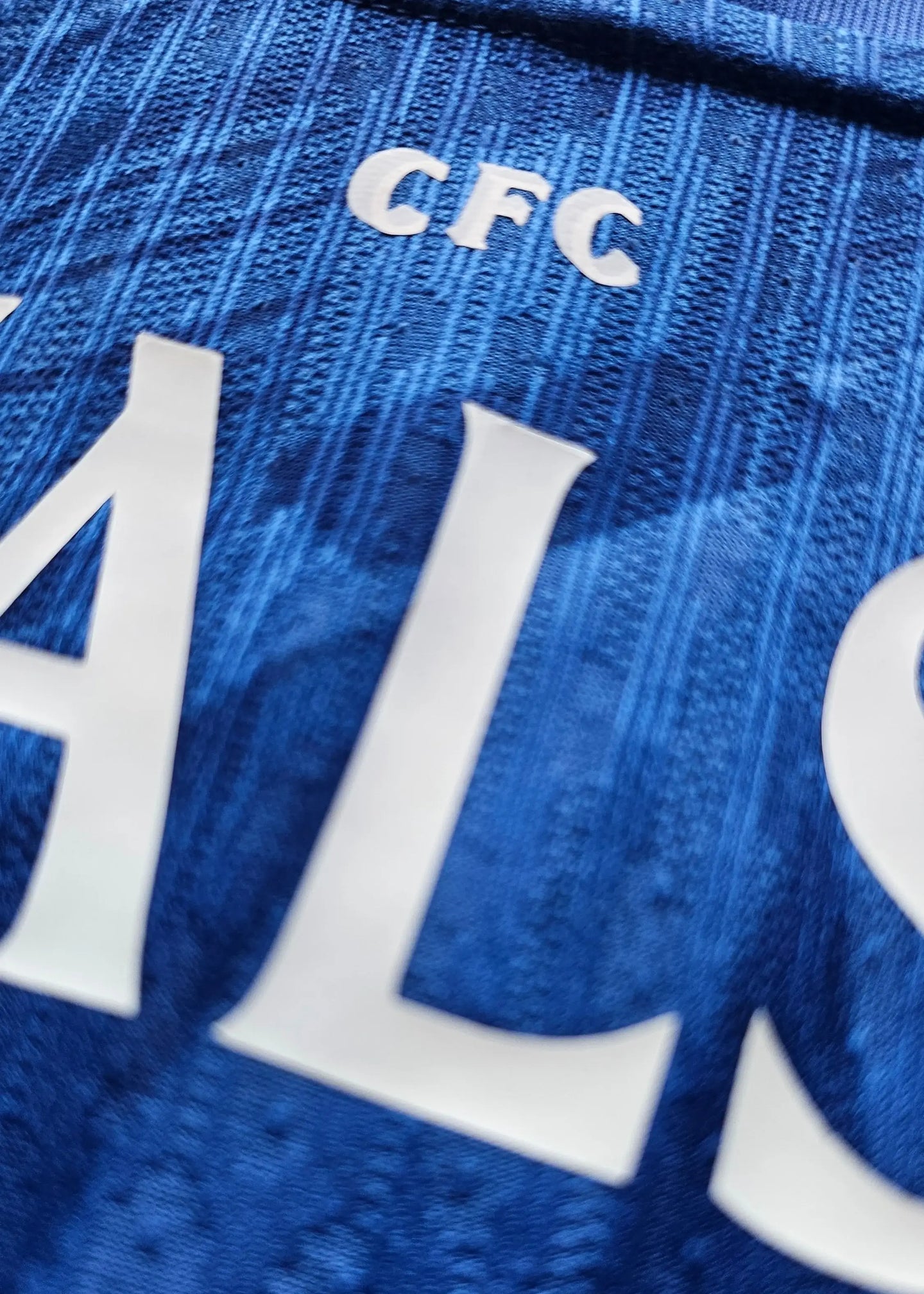Close-up view showing the name Walsh and CFC lettering on a blue Chelsea football shirt.