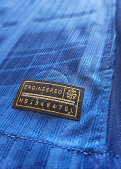 Close-up of the label showing 'ENGINEERED' and code 'MB194847GL' on blue fabric.