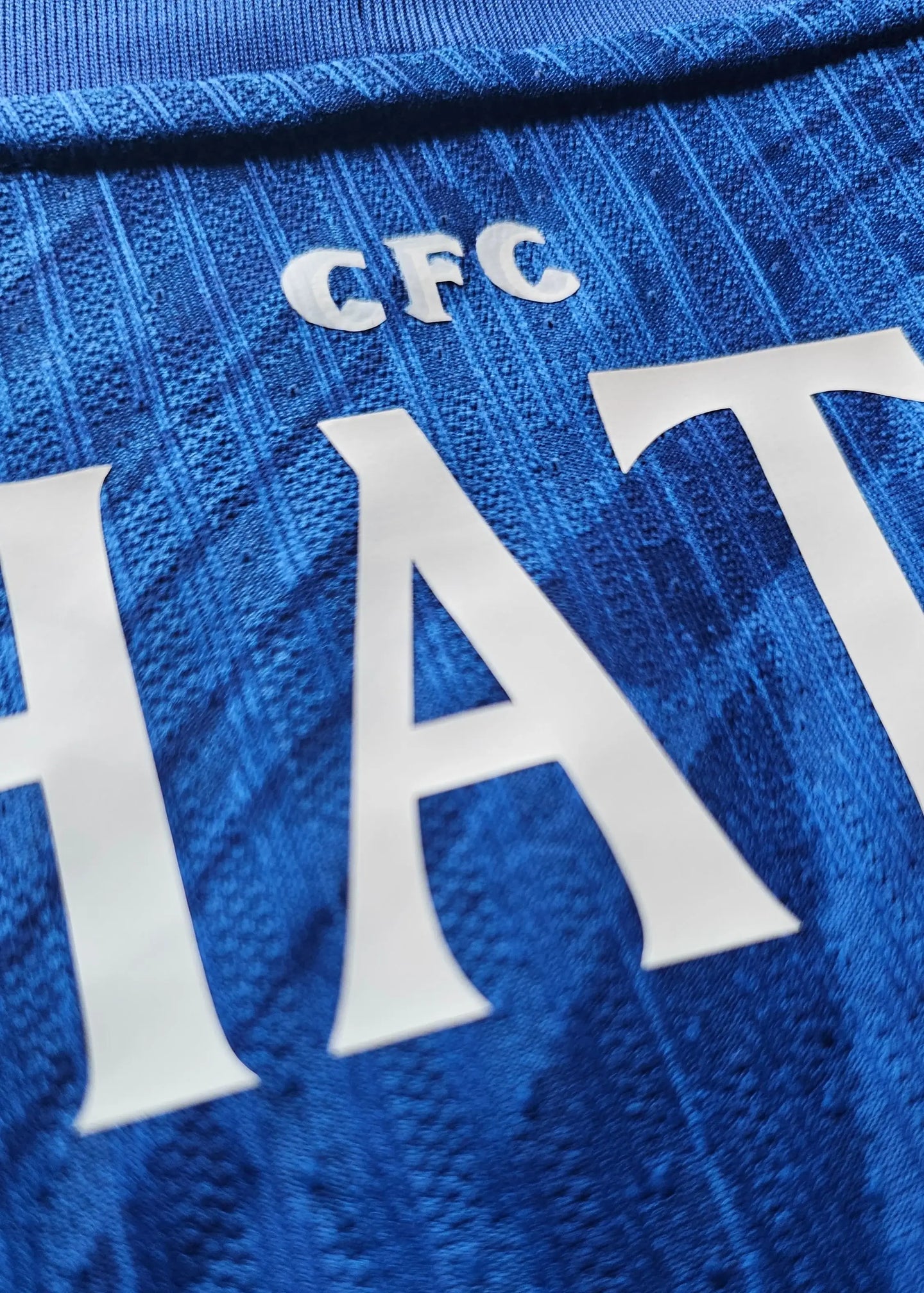 Detail showing the name 'HATO' and 'CFC' on a blue Chelsea football shirt.