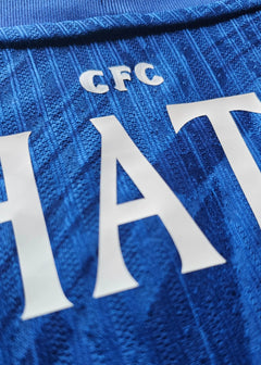 Detail showing the name 'HATO' and 'CFC' on a blue Chelsea football shirt.