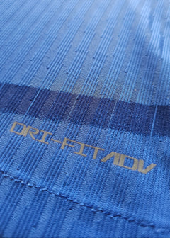 Close-up detail of the DRI-FIT ADV label on a blue football shirt.
