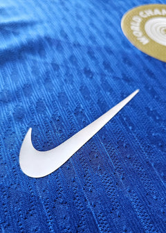 Close-up showing the white Nike logo on a blue football shirt with textured fabric.