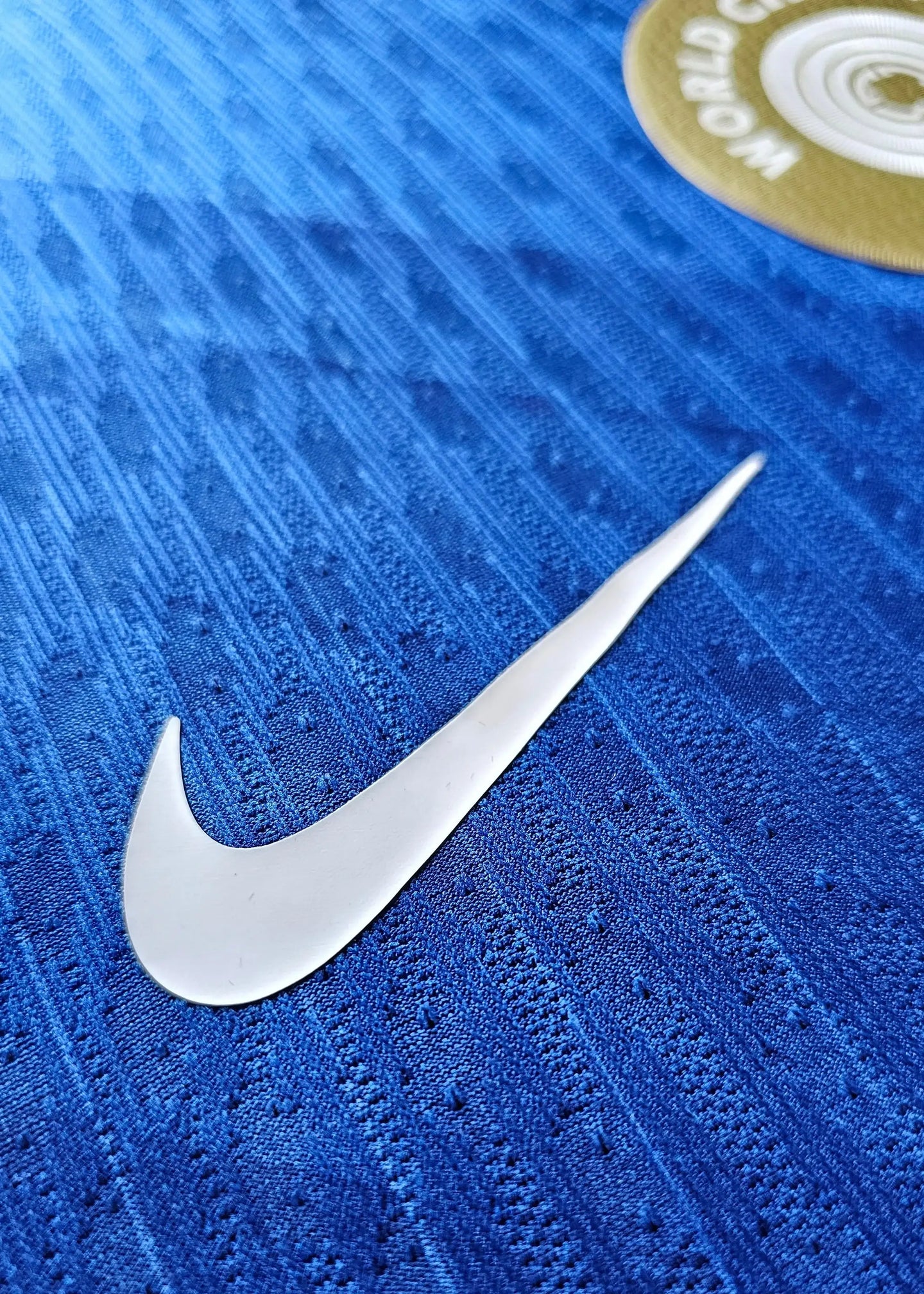 Close-up of Nike logo on blue fabric with textured details.