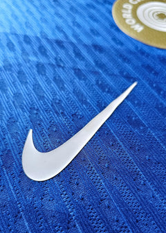 Close-up of Nike logo on blue fabric with textured details.