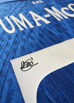 Close-up showing shirt detail with 'Kavuma-McQueen' and signature.