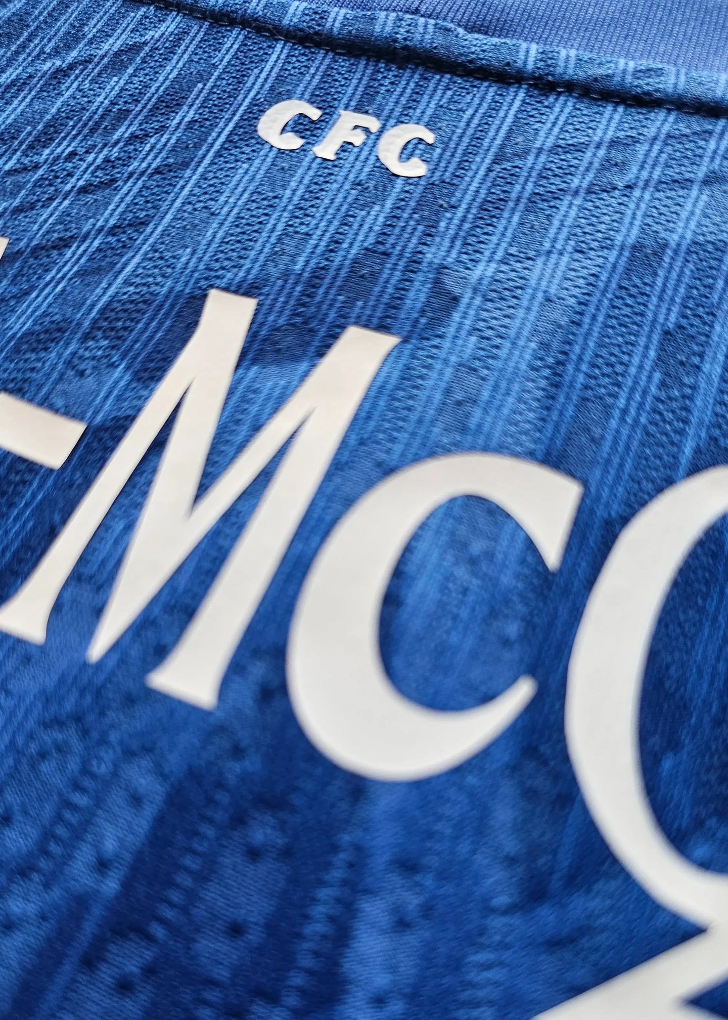 Close-up detail of blue shirt showing 'Kavuma-McQueen' and 'CFC' text.