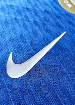 Close-up view of Nike logo on blue fabric texture of Chelsea signed shirt.