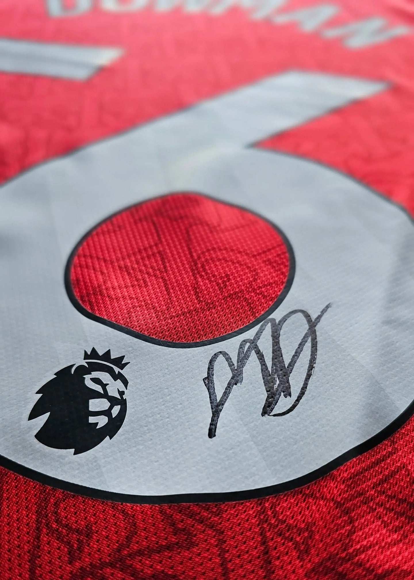 Signature detail with the name Dowman and No. 56 on a red Arsenal football shirt.