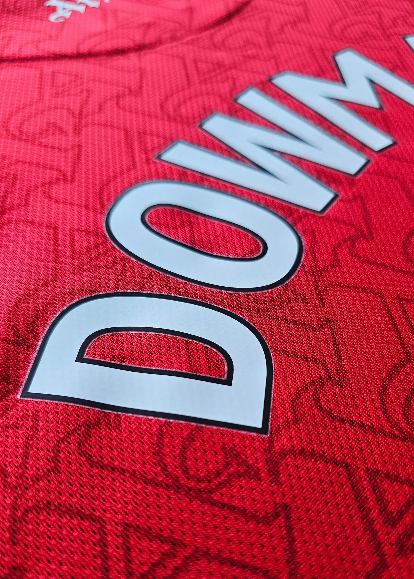 Close-up view showing the name 'DOWMAN' on a red Arsenal F.C. football shirt.