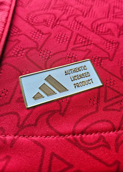 Detail of the red fabric showing the adidas Authentic Licensed Product label.
