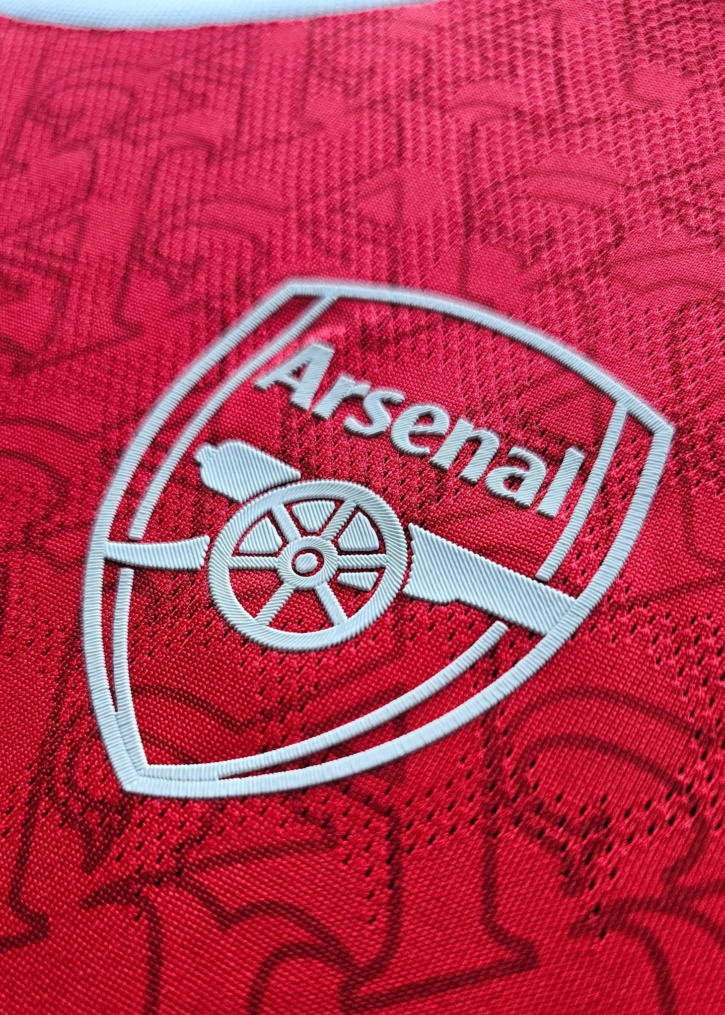 Close-up of the Arsenal crest featuring the club name and cannon emblem in white on a red background.