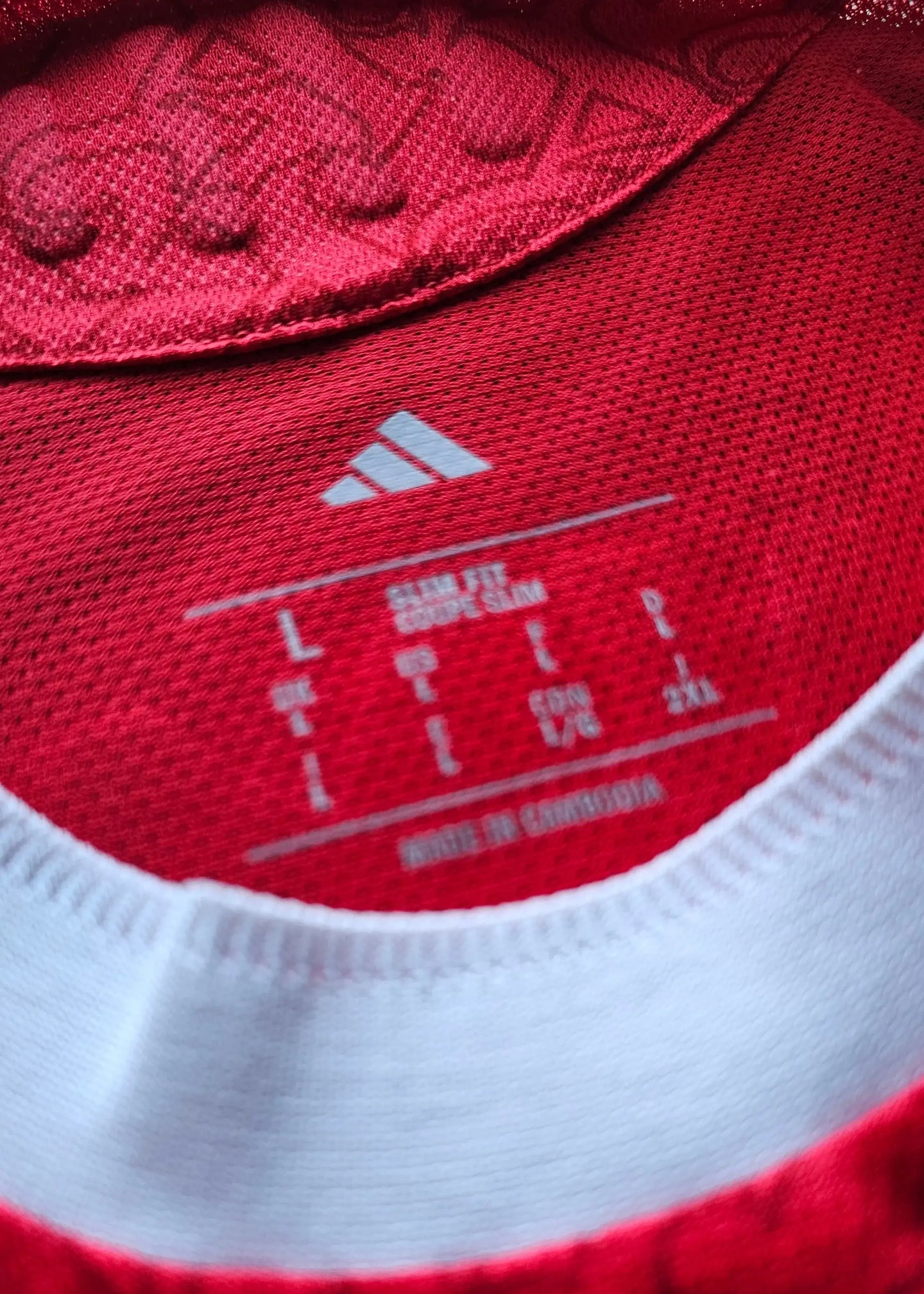 Label detail showing size L, slim fit, and manufacturer adidas, made in Cambodia.