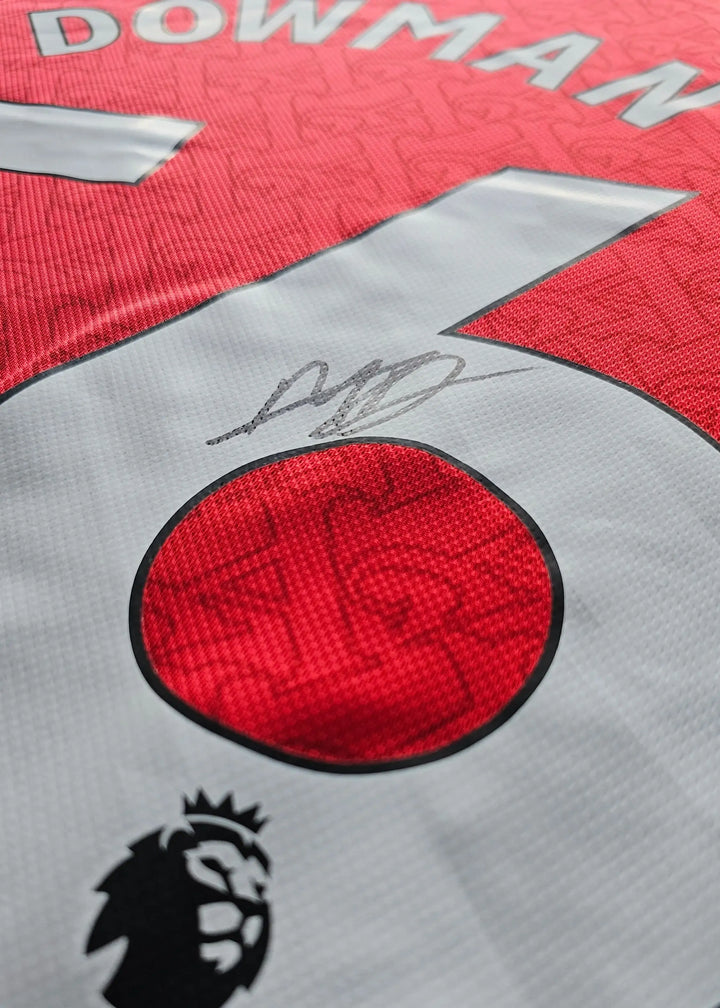 Detail view showing No. 56, Dowman, and signature on red Arsenal football shirt.