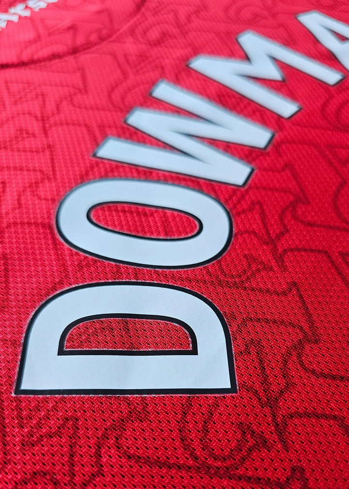 Close-up of the name Dowman and No. 56 on a red football shirt with a textured background.